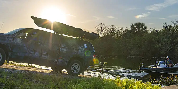 A colorful SUV covered in decals had backed a boat trailer into the water.