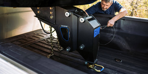 a B&W fifth wheel to gooseneck adapter on an RV that is connected to a gooseneck ball in the bed of a pickup truck