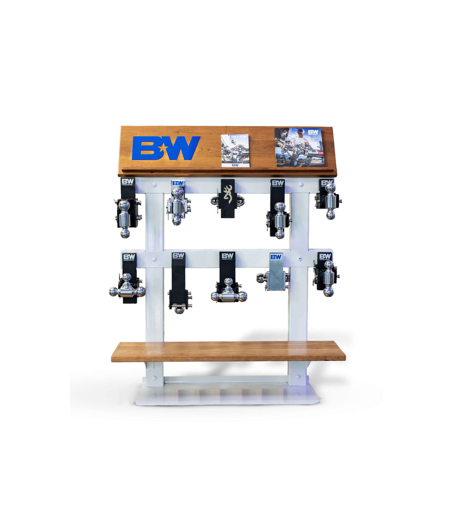 A B&W Tow & Stow display stand filled with hitches, a catalog, and b&w logo