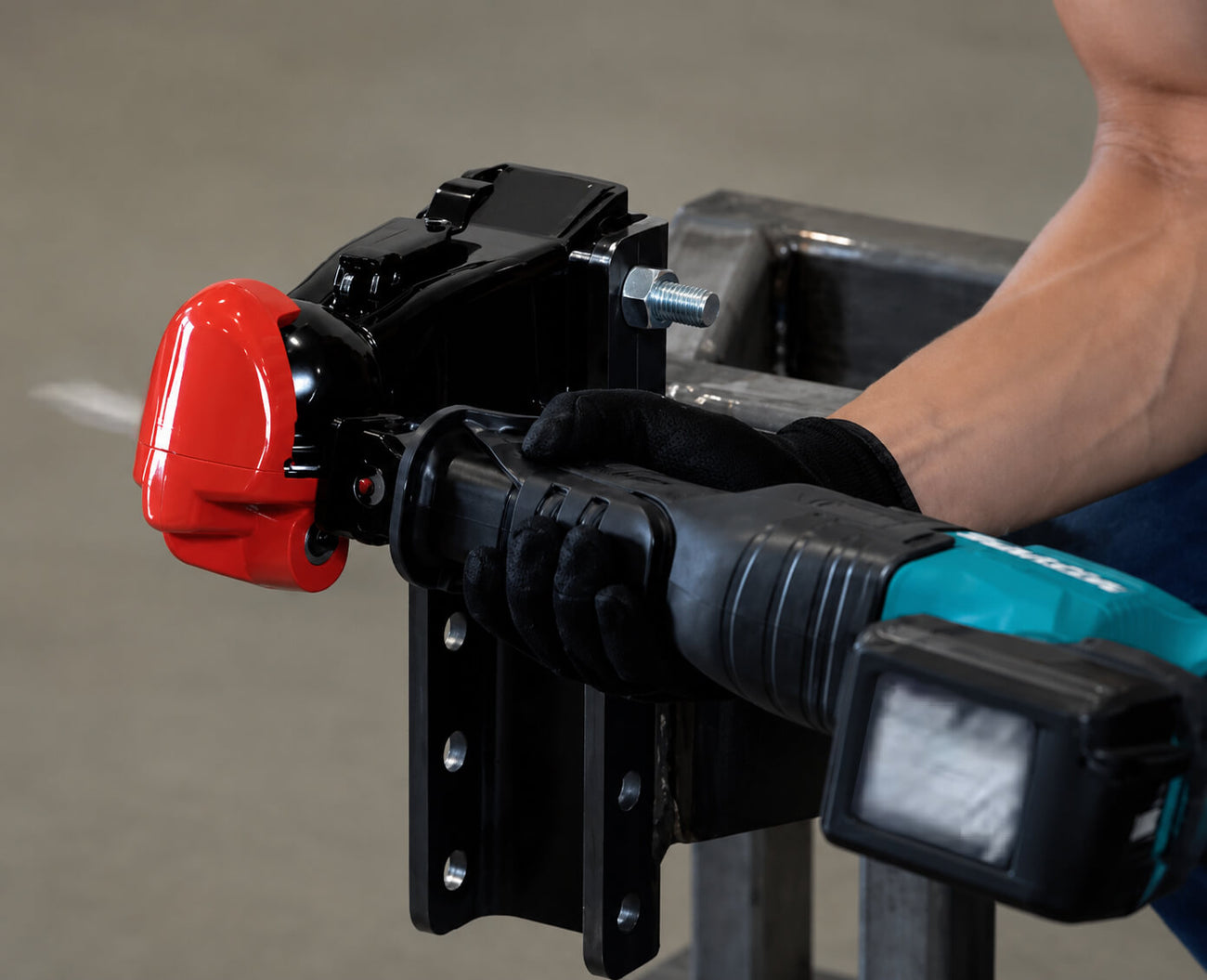 a person using a cutoff saw cutting on a trailer coupler lock