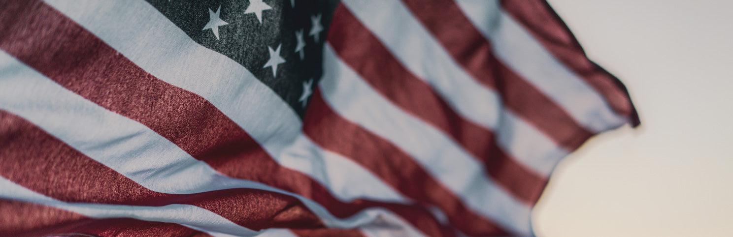 an American flag gently waiving with the sunlight showing through the fabric
