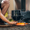 a person kneeling in front of a trailer coupler installing a B&W Icon Trailer Lock.