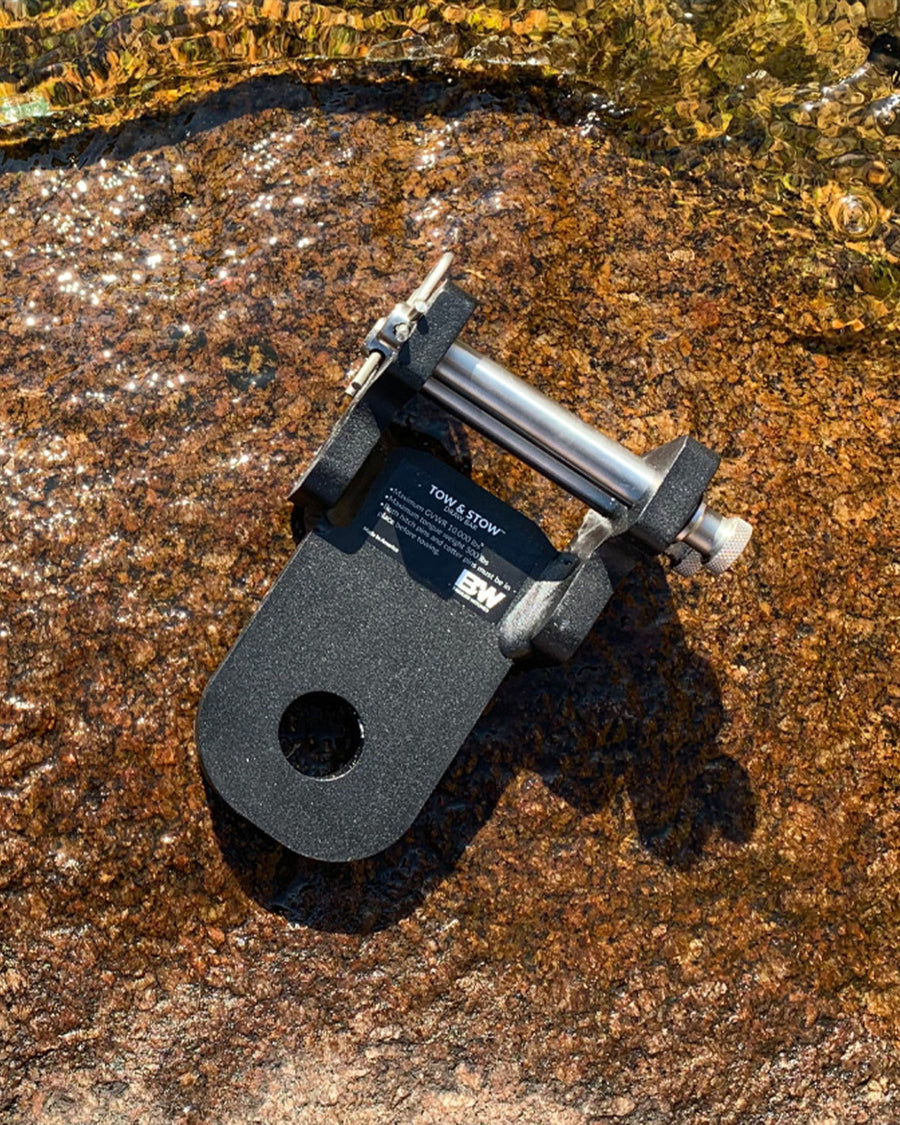 B&W Trailer Hitches draw bar for Tow & Stow sitting on a rock by a stream.