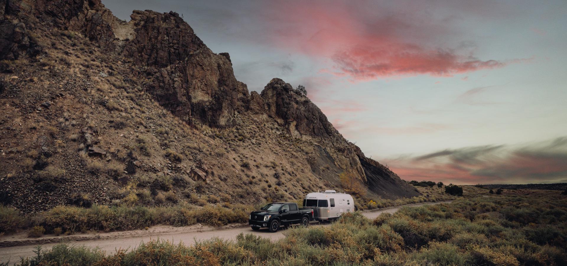 Truck towing an Airstream travel trailer down a scenic road. Stop sway before it happens with the Continuum Weight Distribution Hitch with built-in sway control.